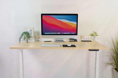 a computer monitor sitting on top of a wooden sit stand desk a computer monitor sitting on top of a wooden sit stand desk