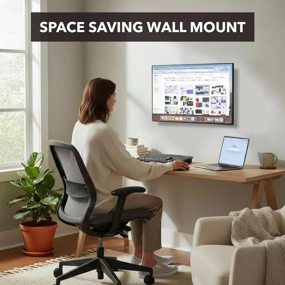 Tilting TV Wall Mount A woman works at a wood desk with a Mount-It! Tilting TV Wall Mount holding her desktop computer, a laptop beside her. The minimal workspace includes a chair and potted plant. Text reads: Space Saving Wall Mount.