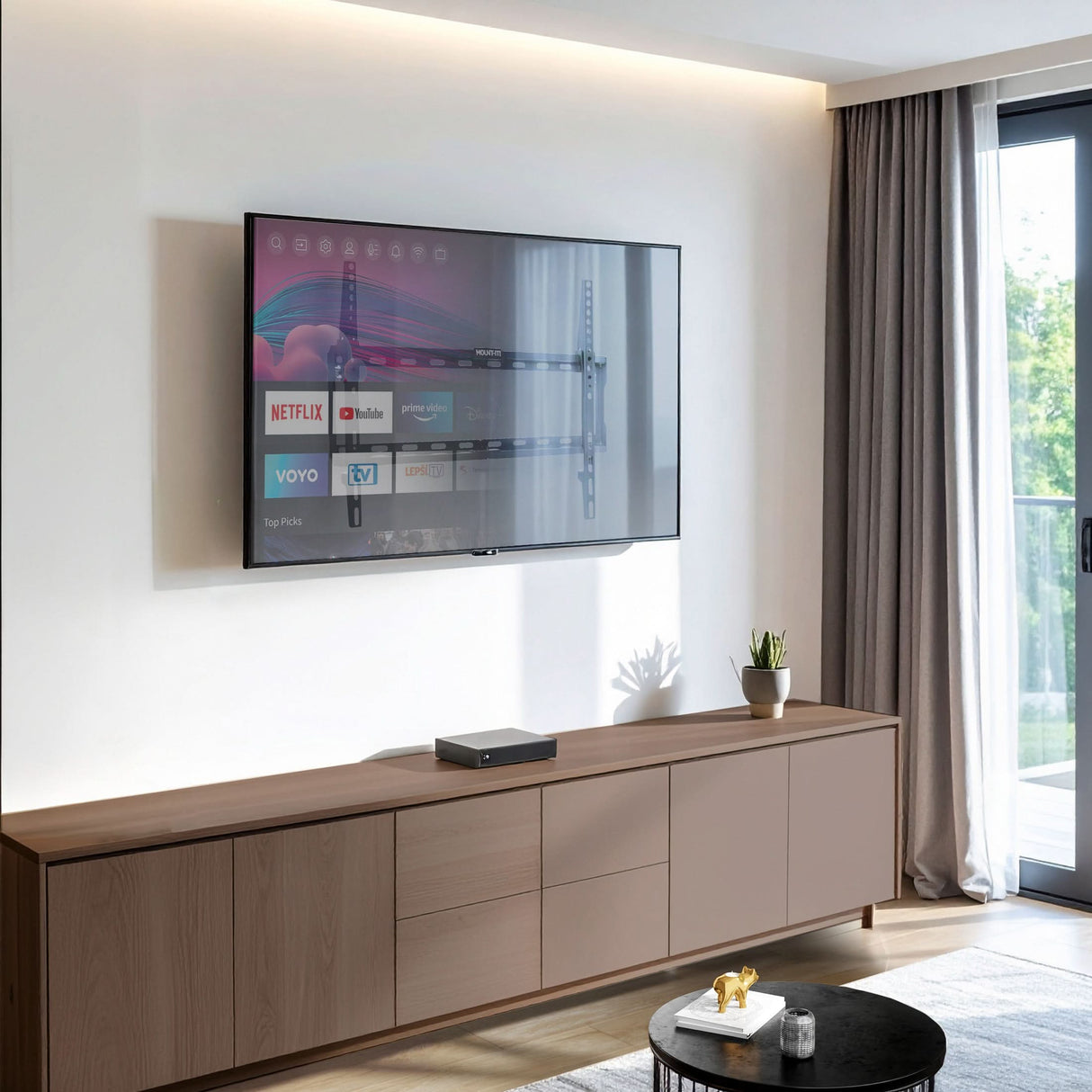 Low Profile Tilt TV Wall Mount Flat-screen TV mounted on a wall using the Mount-It! Low Profile Tilt TV Wall Mount, showcasing its slim one-inch design that holds TVs from 37 to 80 inches securely with adjustable tilt for glare reduction, installed above a modern wooden cabinet in a bright living room with natural light coming through a window.