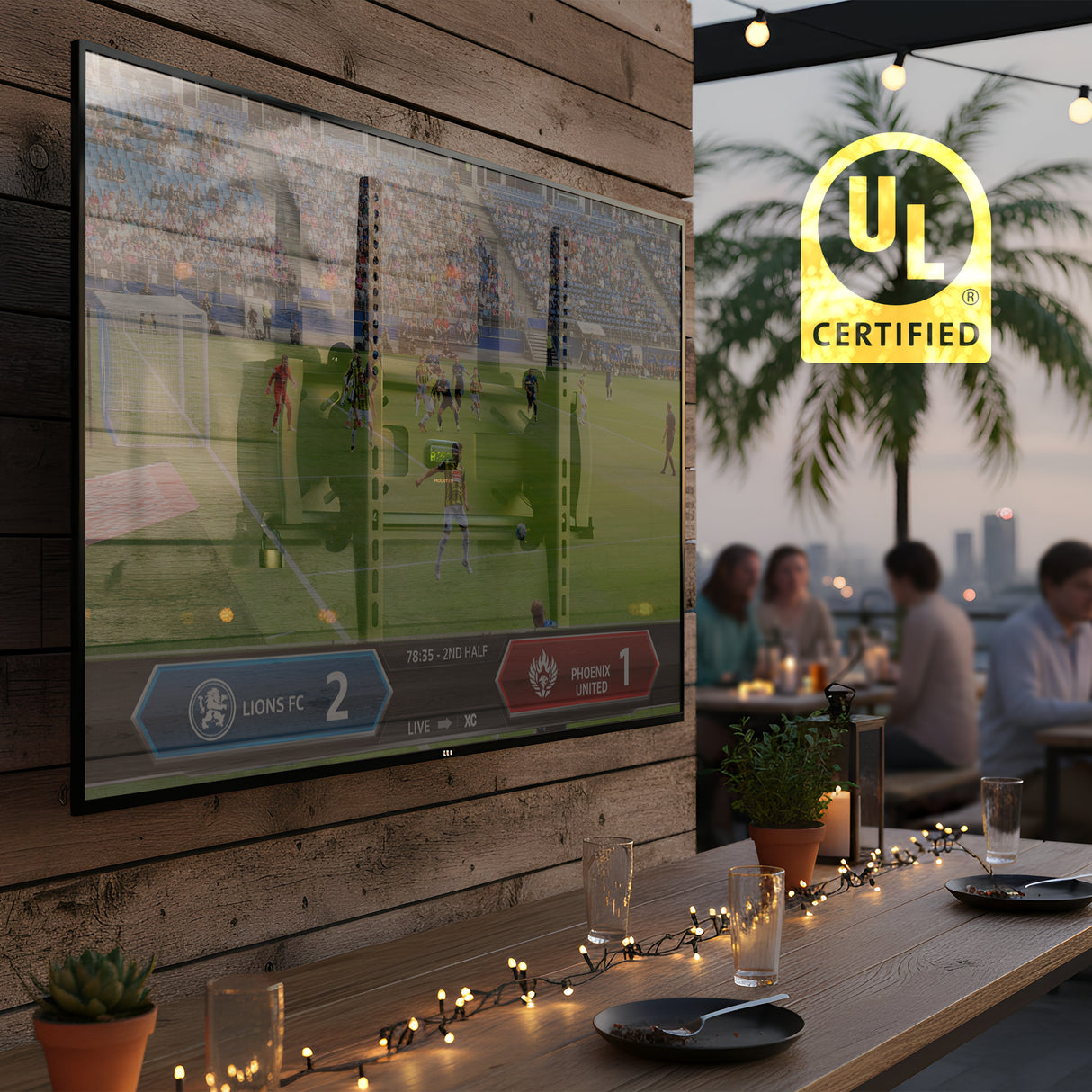 Locking Anti-Theft TV Wall Mount A Mount-It! Locking Anti-Theft TV Wall Mount with VESA 400x400 secures a TV displaying soccer outdoors on a wooden wall as guests dine under string lights, with palm trees, city lights, and the “UL Certified” logo in view.