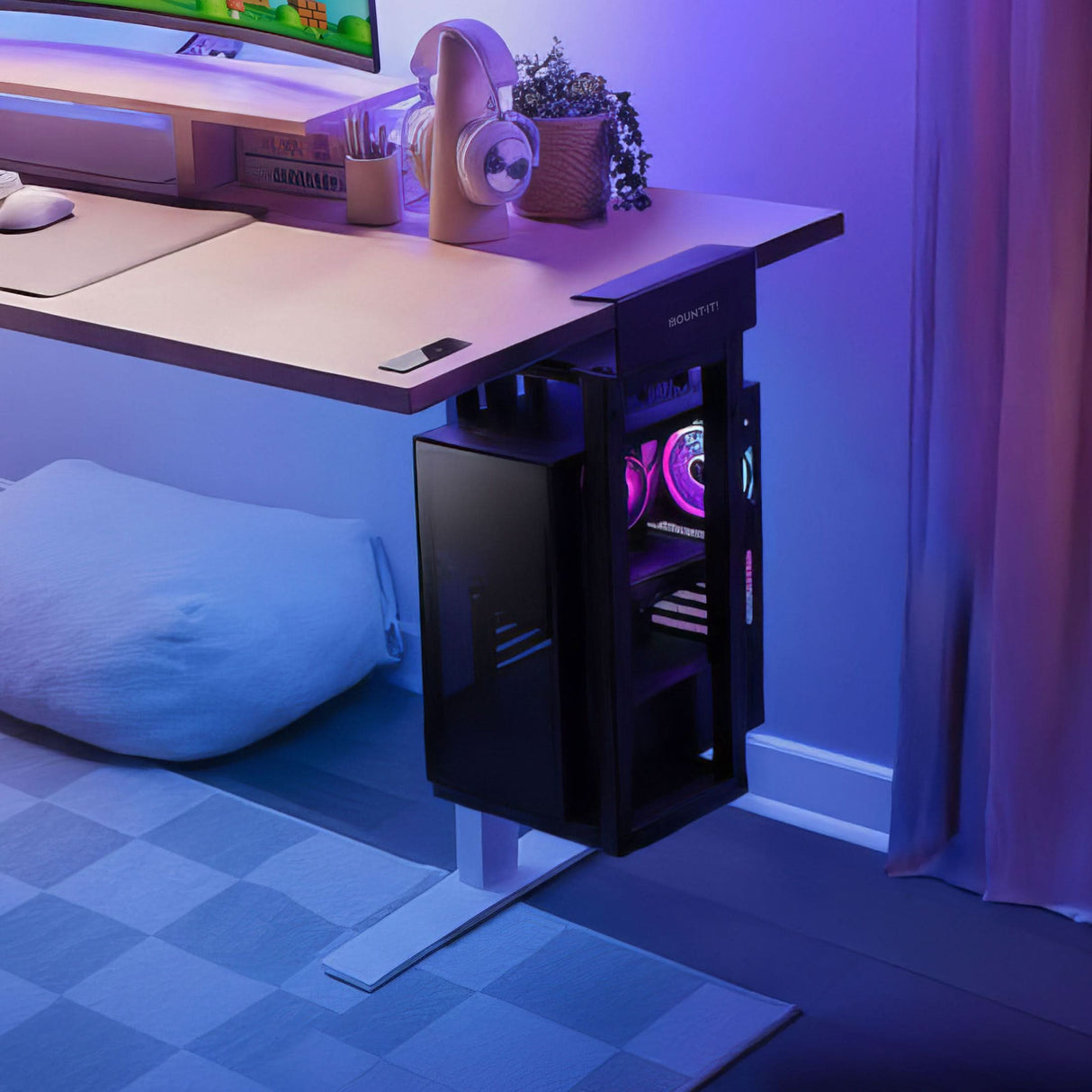 Heavy-Duty Clamp-On CPU Mount A sleek black computer tower with purple lighting rests in the Mount-It! Heavy-Duty Clamp-On CPU Mount under a white desk by a window. The desk displays a monitor, headphones, and plants bathed in blue and purple ambient lighting.