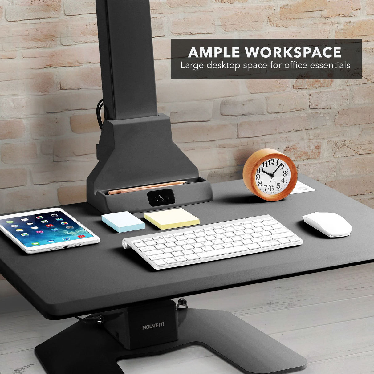 Electric Standing Desk Converter for 1 Monitor Black electric standing desk converter with office essentials on a wooden desk and brick wall background