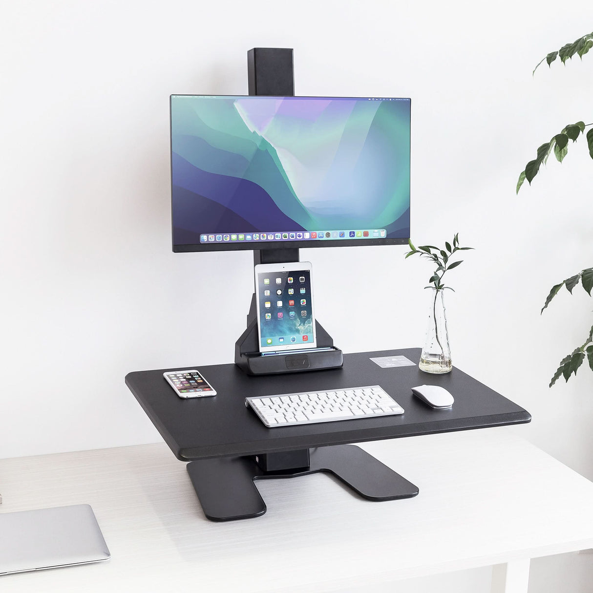 Electric Standing Desk Converter for 1 Monitor Black adjustable desk converter with computer monitor, tablet stand, keyboard, and mouse on a white surface.