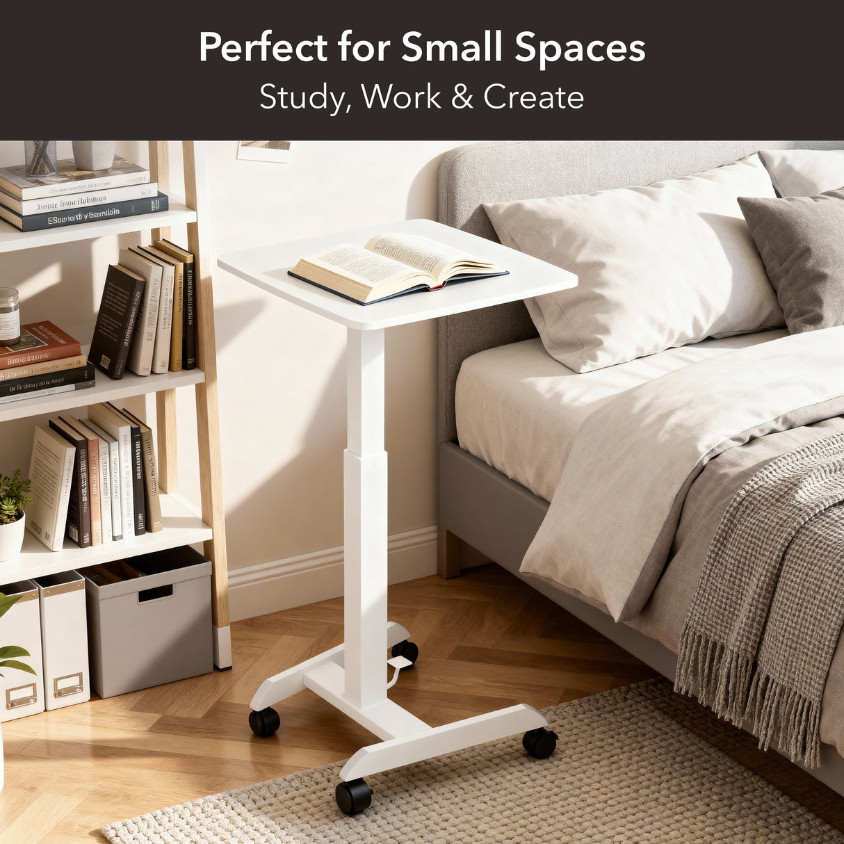 A Mount-It! Height Adjustable Rolling Laptop Desk in white sits beside a bed in a cozy, organized bedroom. Books and decor fill nearby shelves. Text: Perfect for Small Spaces—Study, Work & Create.