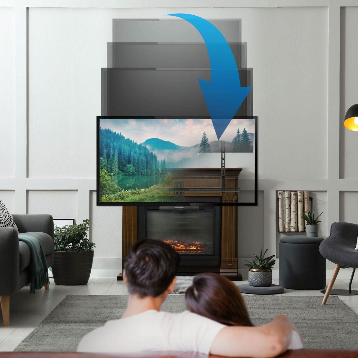 A couple relaxes on a sofa as the Mount-It! Pull Down Fireplace TV Mount lowers the TV in front of their fireplace. The modern room is decorated with plants, shelves, and a floor lamp. A blue arrow highlights the mount’s height adjustability.