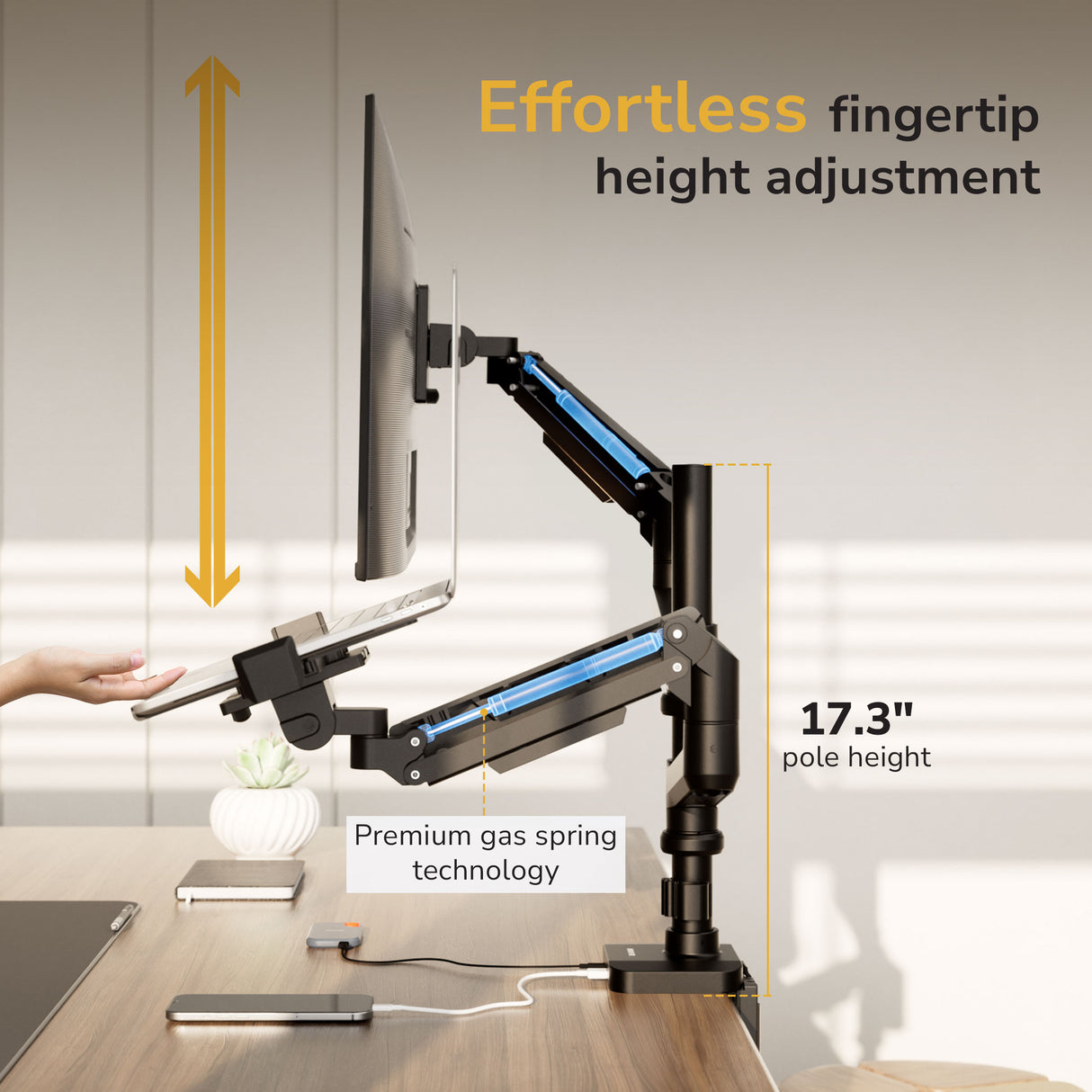A user adjusts the Mount-It! Heavy-Duty Monitor and Laptop Mount, featuring black gas spring arms with blue accents. Text reads Effortless fingertip adjustment and 17.3" pole height—an ideal ergonomic dual mount for your workspace.