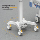 The Mount-It! MedHub Compact Mobile Workstation is shown on a gray floor, featuring four large locking casters. Labels indicate the base and wheel sizes. Part of a hospital bed is visible, with text highlighting its compact, mobile design.