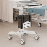 A Mount-It! MedHub CPU Holder workstation with a side-mounted CPU holder and keyboard tray is positioned beside a hospital bed and privacy curtain, with medical equipment visible in the background.