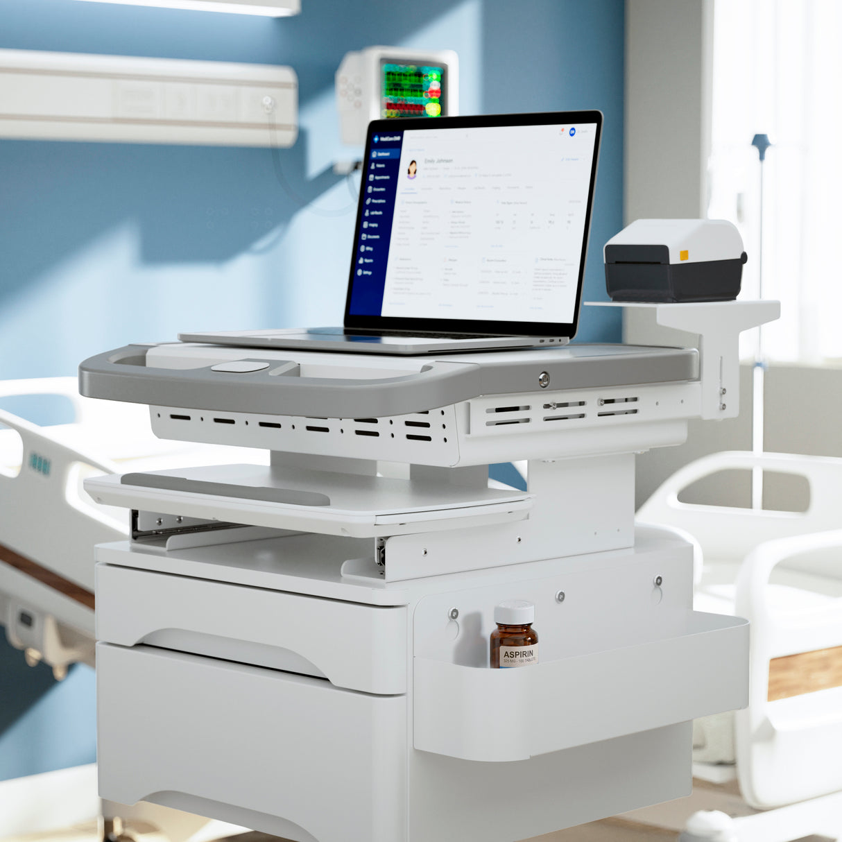 A Mount-It! MedHub Printer Holder cart with medical equipment and a laptop displaying records stands by a hospital bed in a brightly lit patient room, next to an Aspirin bottle.