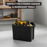 A Mount-It! Heavy-Duty Storage Bin with Lid filled with tools sits on a workshop floor. In the background, a workbench with neatly arranged tools and storage bins is visible. Text reads: Perfect for storing garage & workshop tools.