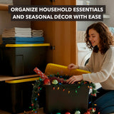 A woman organizes seasonal décor in a Mount-It! Heavy-Duty Storage Bin with Lid in her laundry room. Folded towels and other bins are nearby. Text: Easily organize household essentials with Mount-It! storage solutions.