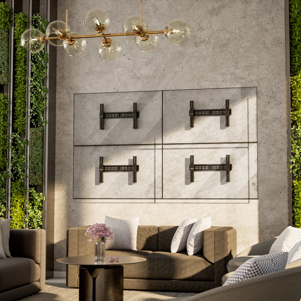 Modern living room with a concrete accent wall featuring four Mount-It! Pop-Out Video Wall Mounts in a grid. Brown sofas, a round table with pink flowers, and gold chandelier add elegance, while vertical plant panels provide lush contrast.