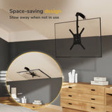 A minimalist bedroom features a flat-screen TV installed with the Mount-It! Flip-Down Ceiling TV Mount. An inset shows the TV folded to the ceiling. Text reads: Space-saving design. Stow away when not in use.