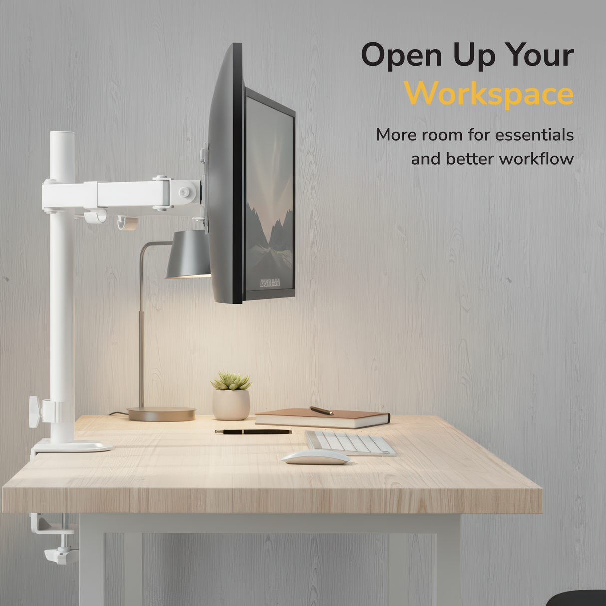 A modern desk setup features two monitors on the Mount-It! Full Motion Dual Monitor Desk Mount, plus a lamp, keyboard, mouse, and phone on a light wood desk. Text: Open Up Your Workspace—more essentials and ergonomic screen positioning.