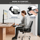 A woman sits at a desk using the Mount-It! Adjustable Keyboard Tray and Mouse Platform w/ Wrist Rest Pad, featuring safety end caps, pressure-relief support, and guidance for a 7-inch gap between tabletop and knees for comfort.