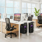 A modern, bright office with large windows, sleek desks, black office chairs, desktop computers in Mount-It! Heavy-Duty Clamp-On CPU Mounts with purple lighting under the desks, and a green plant in the corner.