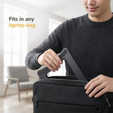 A person in a dark sweater slips the Mount-It! Portable Folding Laptop Stand into a black laptop bag. Text on the image says, “Fits in any laptop bag,” set against a bright, modern room.