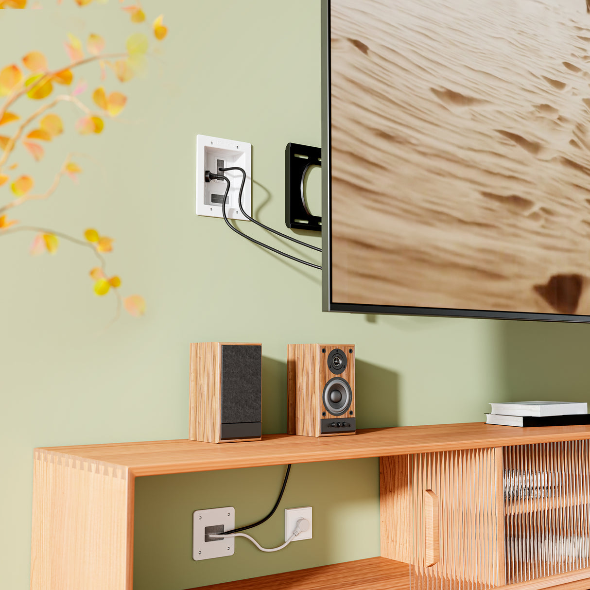 A wall-mounted TV with visible cables and a white wall plate above a wooden shelf housing speakers and an audio receiver could look neater by using the Mount-It! In-Wall Cable Management Kit with USB for improved cable organization.