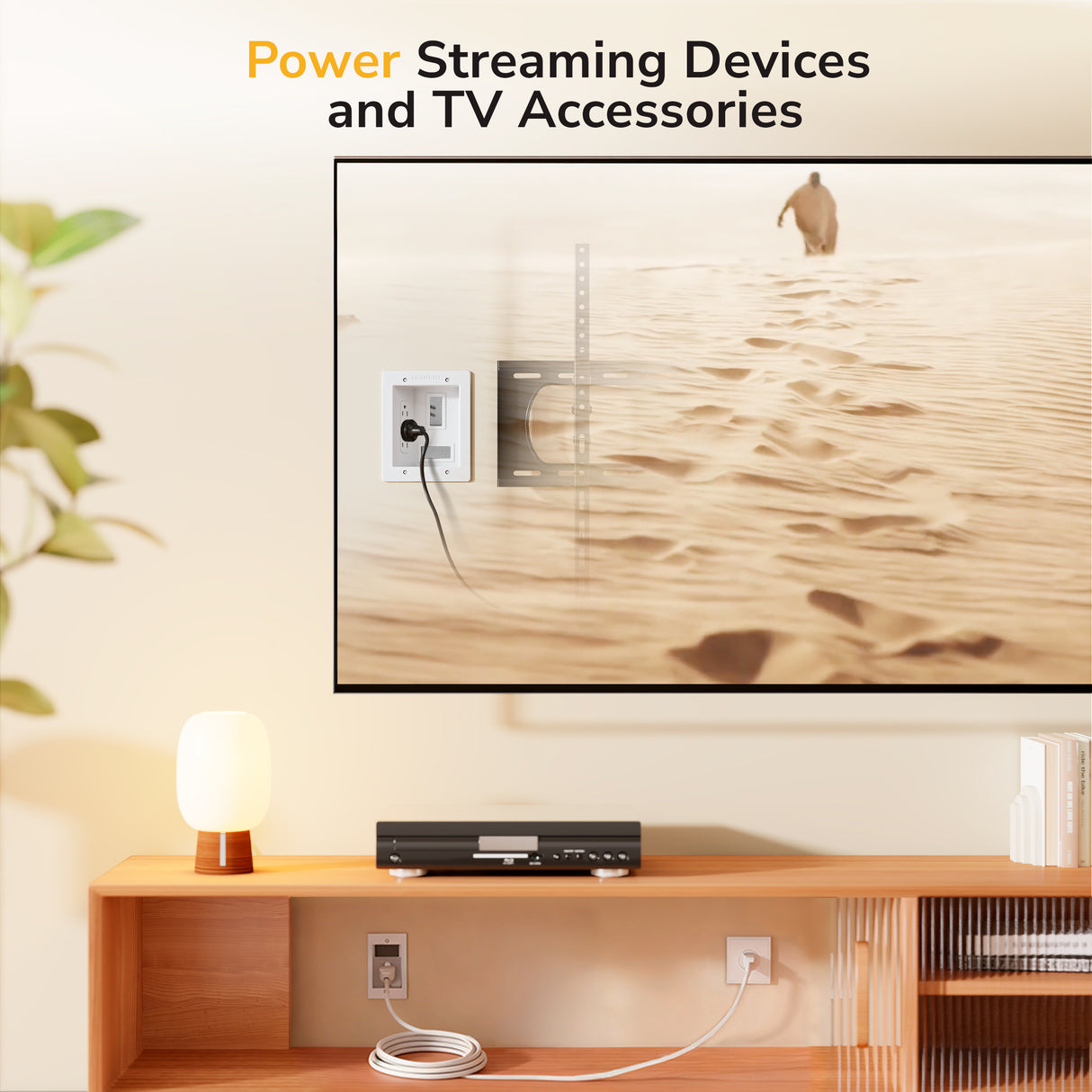 A TV on a wall shows a desert scene. Text above: Power Streaming Devices and TV Accessories. On the shelf: lamp, streaming device, books—and the Mount-It! In-Wall Cable Management Kit with USB and Power Input Module for a tidy setup.