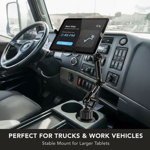 The Mount-It! Heavy-Duty Cup Holder Tablet ELD Mount is installed in a truck cab’s console, displaying navigation. Perfect for trucks and work vehicles, this stable mount securely holds larger tablets.