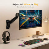 A modern desk setup features a Mount-It! Single Monitor Wall Mount Arm displaying a racing game, with an RGB keyboard, mouse, headphones on a stand, cup, lamp, and smartphone. Text above reads: Adjust for Work or Play. Comfortable viewing all day.