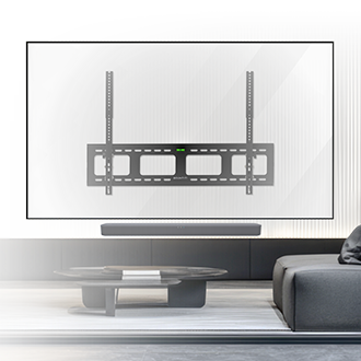 Minimalist living room with a black TV wall mount centered on a white wall, above a long soundbar. A low black coffee table and sectional sofa are in the foreground.
