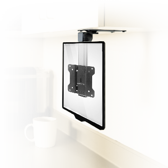 A flat-screen TV wall mount is installed under a white cabinet, with a blurred white mug in the background on a countertop.